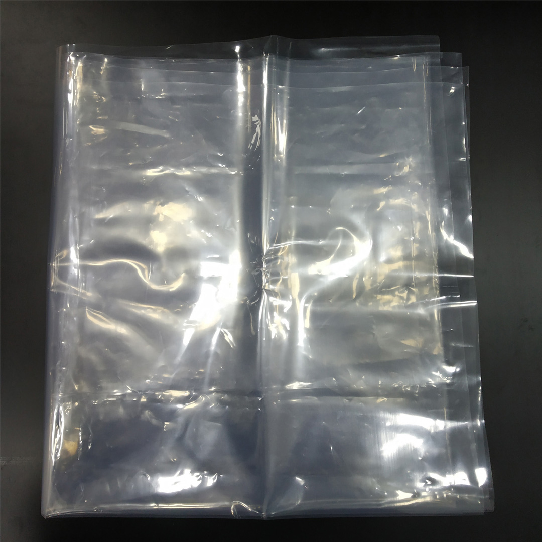 Folded translucent clear PEVA plastic film sheet set flat on a dark background.
